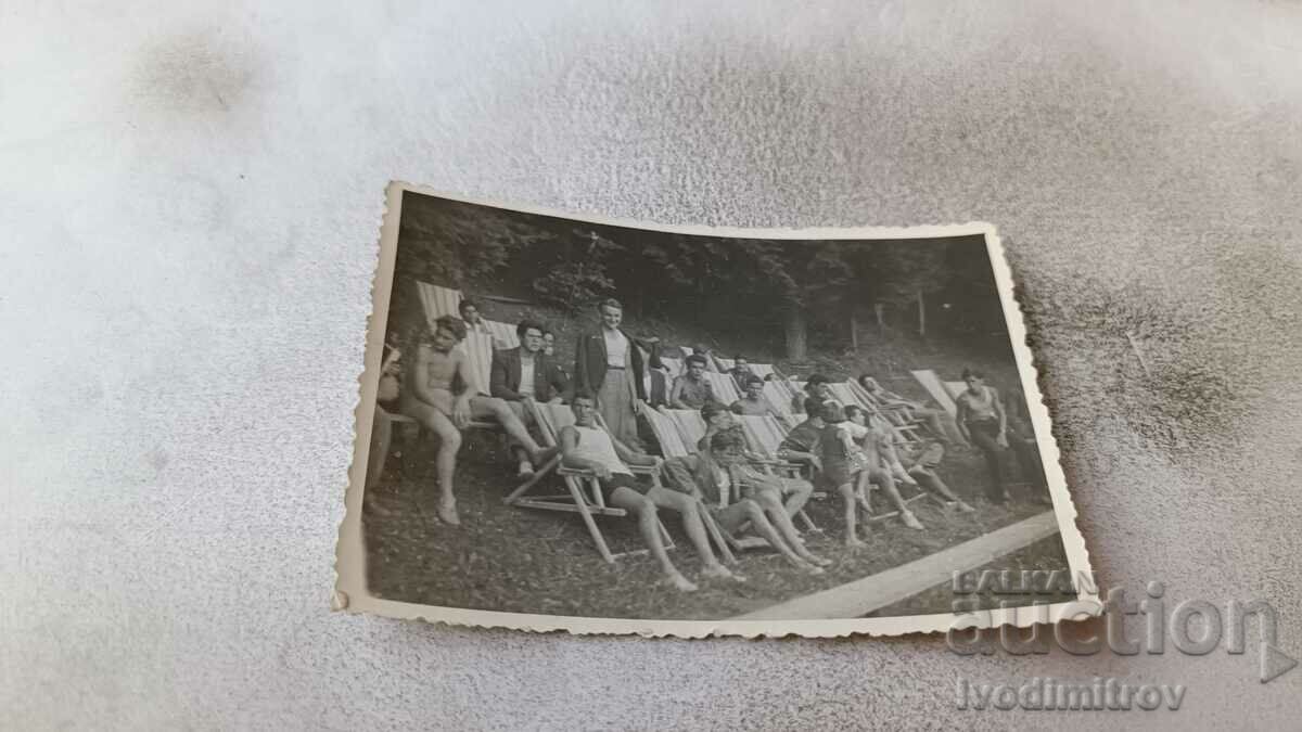 Photo Young people in swimsuits on wooden deckchairs