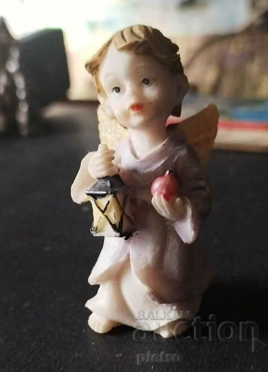Retro figurine of a standing angel with a lamp in his hand.