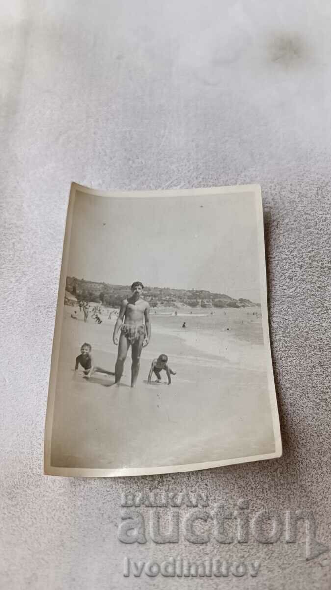 Photo Man and two children on the beach 1957