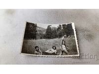 Photo Two young men naked to the waist and a girl on the grass