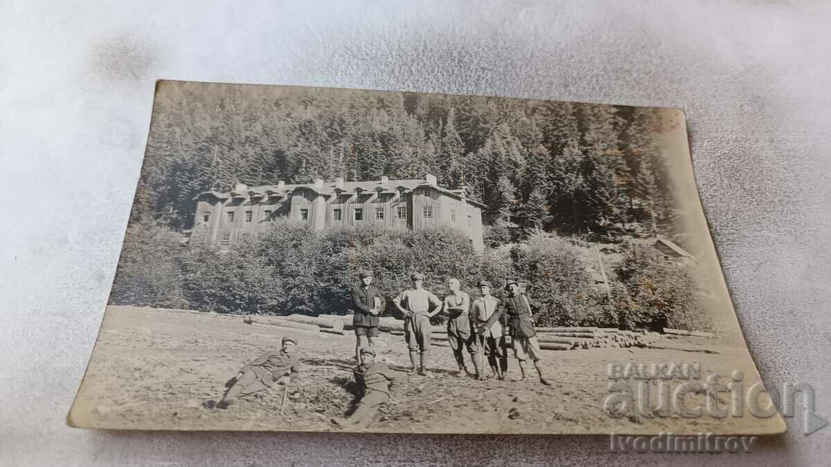 Foto Bărbați în fața buștenilor în munți