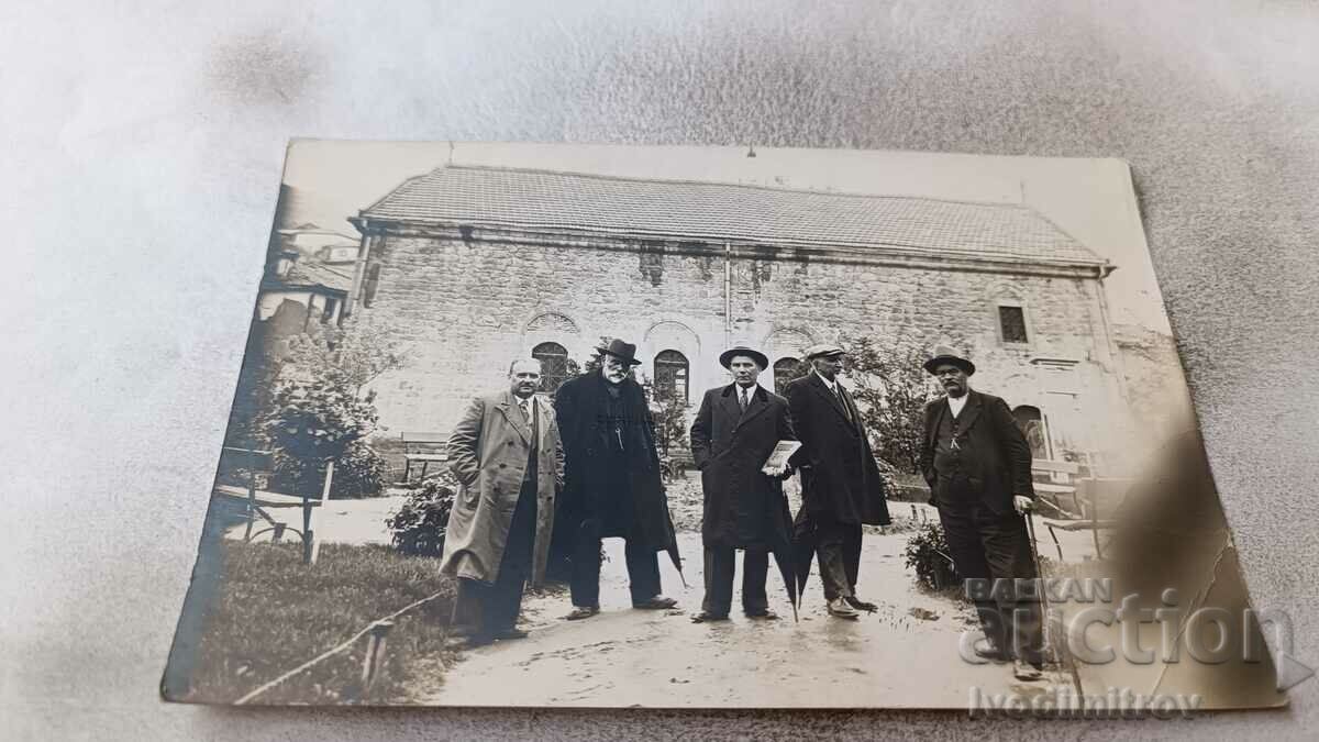Foto Bărbați în fața unei clădiri antice