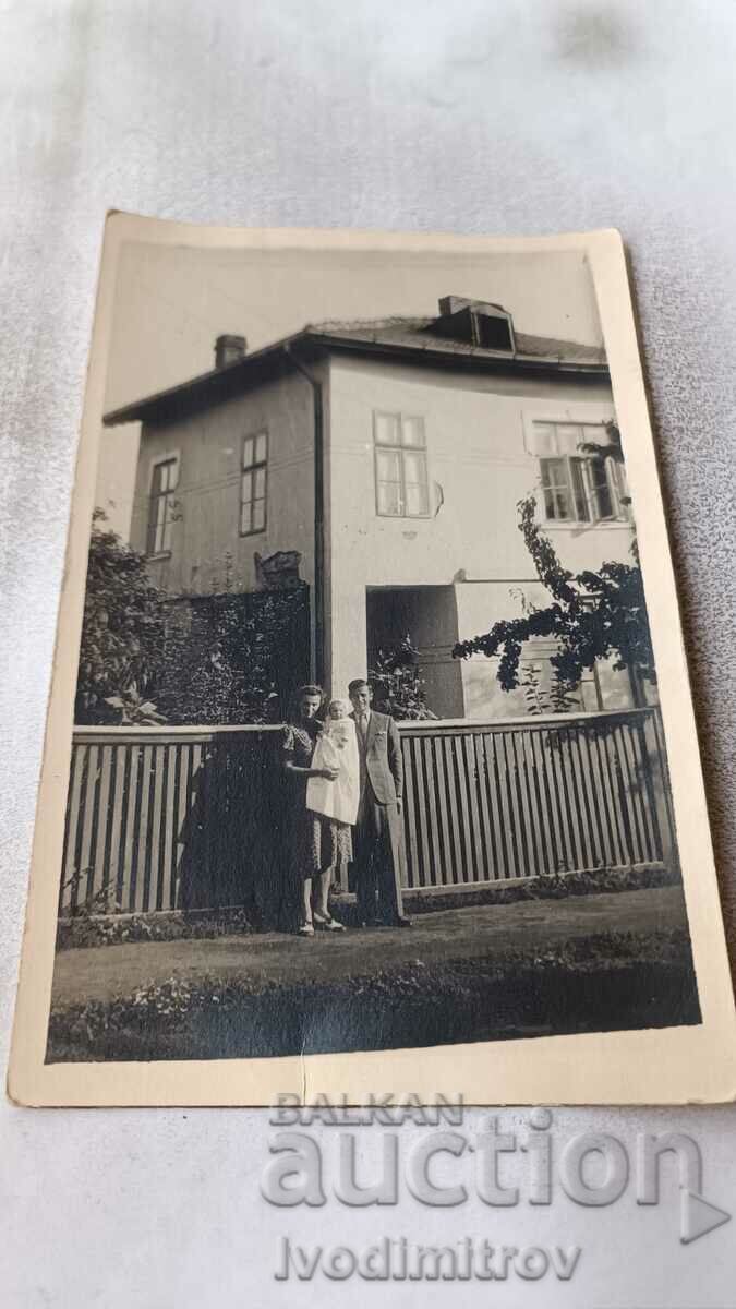 Photo Man, woman and baby in front of a newly built house