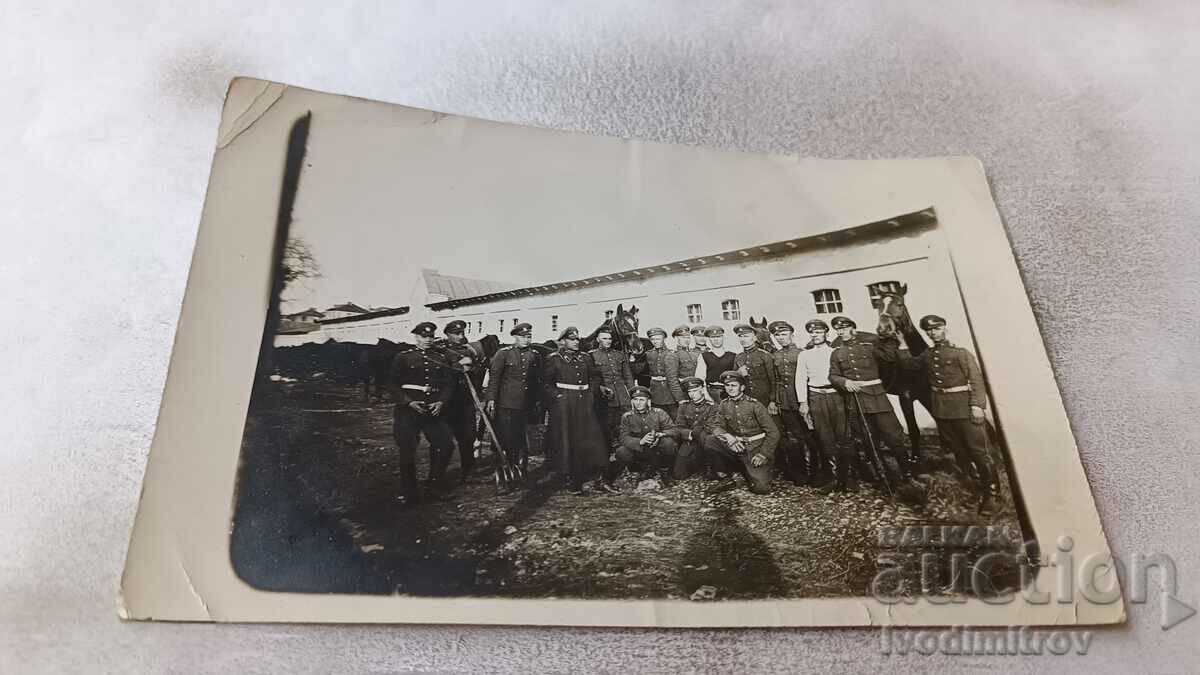 Photo Cavalrymen with three black horses in the barracks
