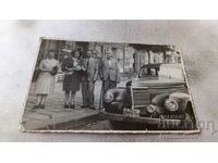 Photo Sofia Men and women on the sidewalk next to a vintage car 1947