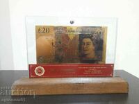 Banknotes Pounds gold in a glass holder and solid wood