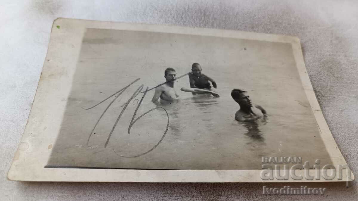 Photo A man and two young men in the sea