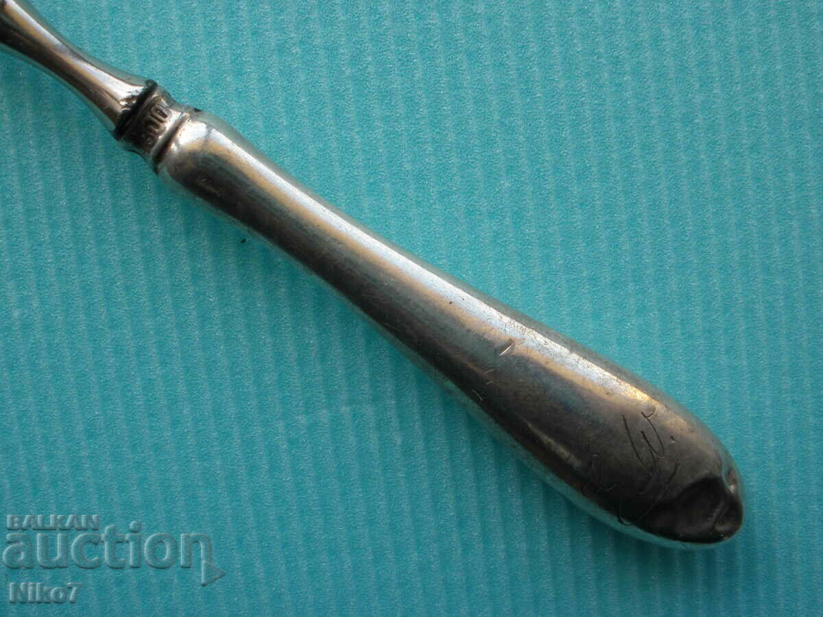 Auction  Antique tweezers with a silver handle.
