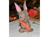 Old plastic retro rabbit figurine with carrot.