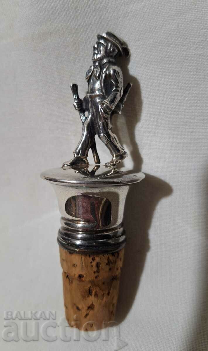 Old silver-plated cork with a plastic figure