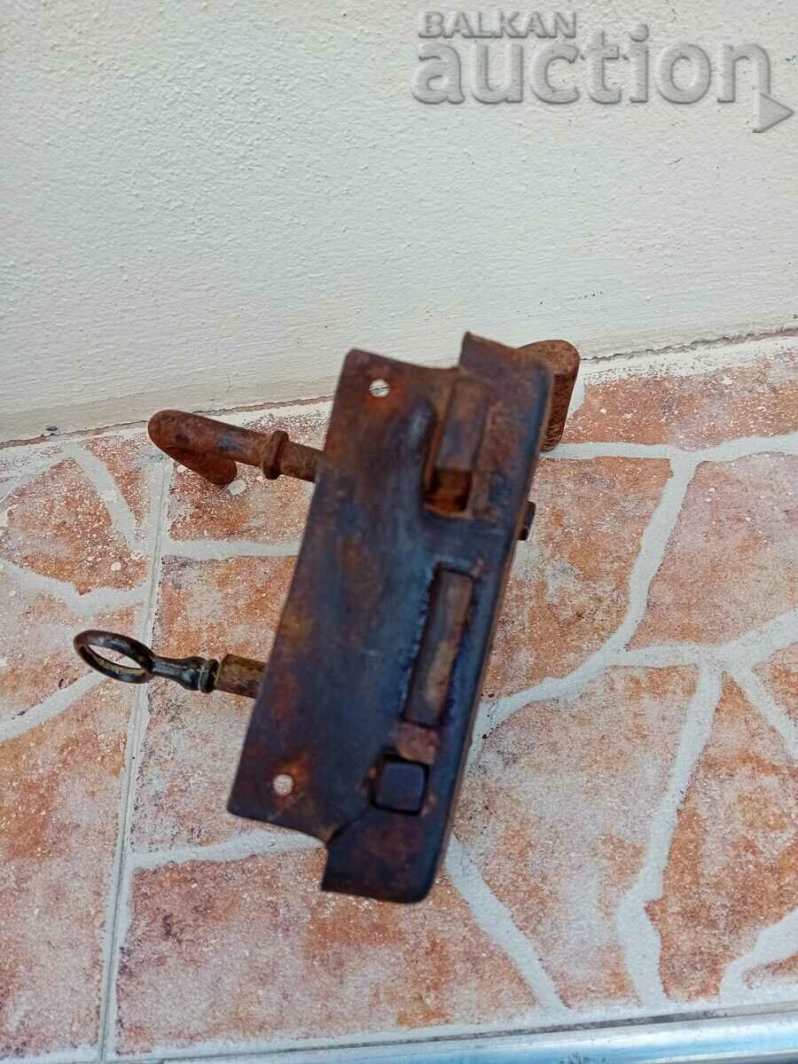 μια παλιά πρωτόγονη κλειδαριά με ένα κλειδί