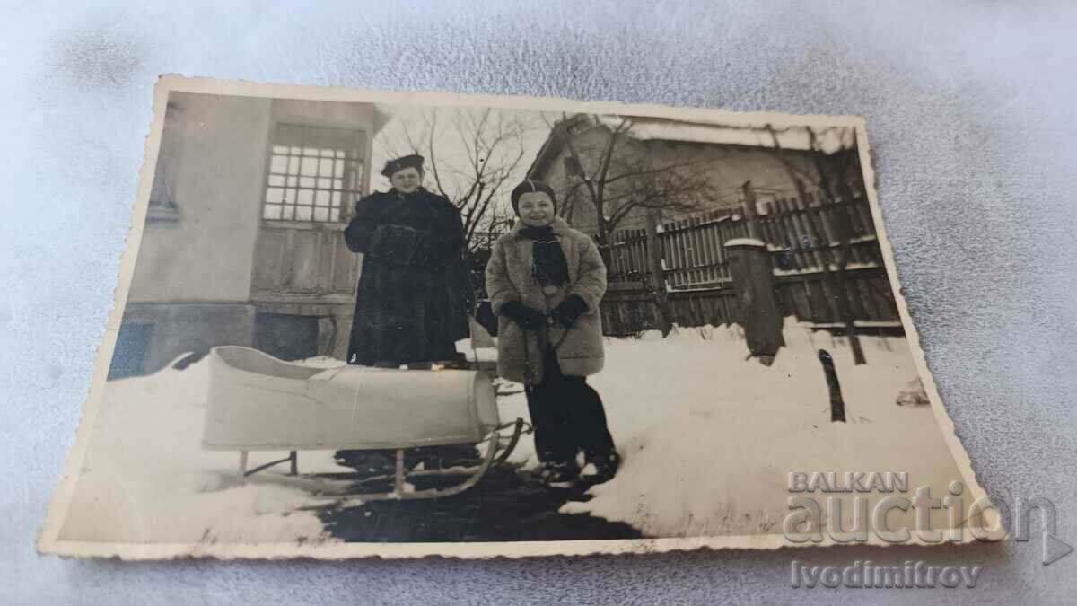 Photo Sofia A woman and a boy with a sled in the yard in the winter of 1939