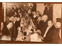 Priest and wedding guests at a table