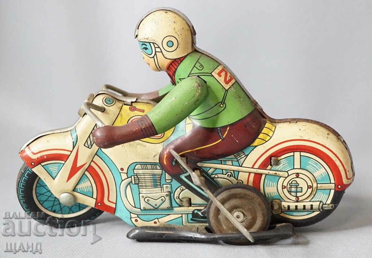 Old metal mechanical toy model bike with biker