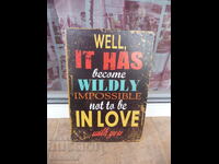 Metal sign with a message about love, falling in love, etc.
