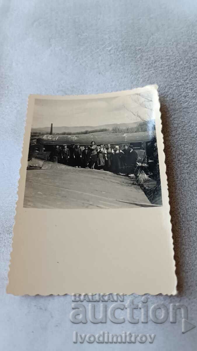 Photo Men and women in front of a factory