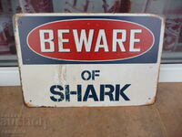 Metal sign inscription Caution sharks danger Jaws people