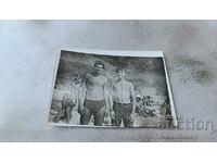Photo Two young men in swimsuits on the beach