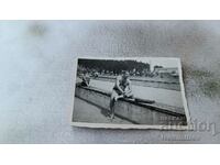 Снимка Мъж по бански седнал на дървена платформа