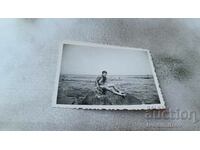 Fotografie Tânăr în costum de baie pe o stâncă lângă mare