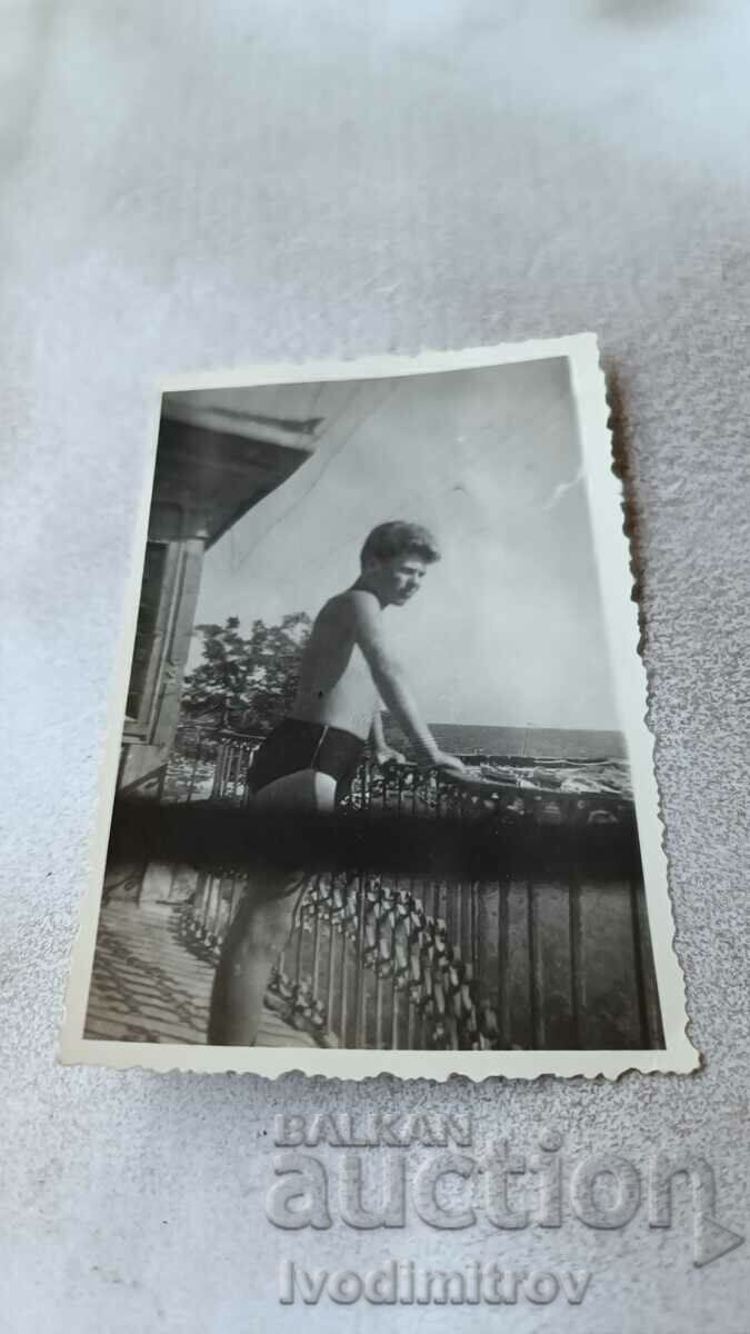 Fotografie Un tânăr în costum de baie pe terasă