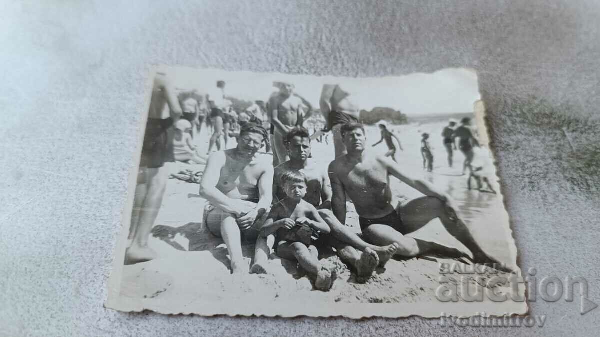 Imagine Trei bărbați și un băiețel pe plajă