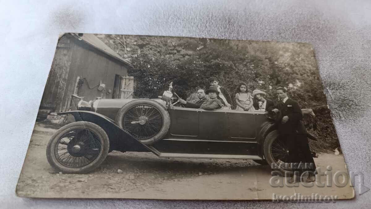 Снимка Двама мъже жени и деца с ретро лек автомобил