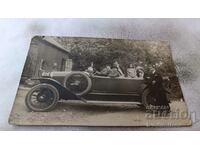 Снимка Двама мъже жени и деца с ретро лек автомобил