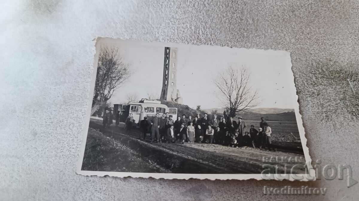 Photo Men and women in front of a vintage bus on the road
