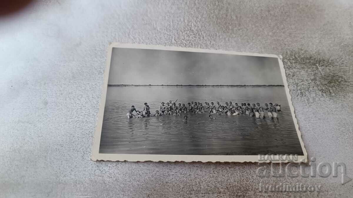 Foto Bărbați și tineri în costume de baie în mare