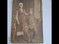 A soldier with an order of bravery and a woman in a costume old PSV photo