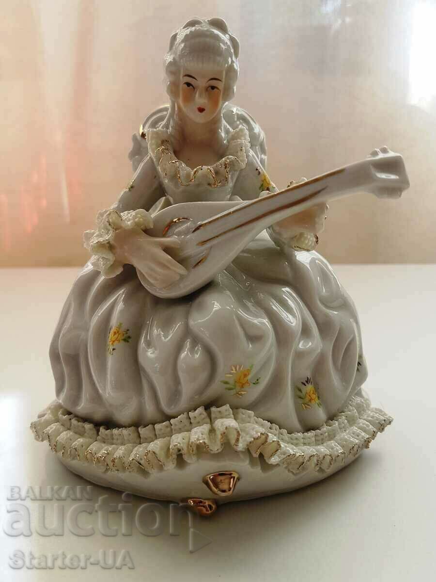 A beautiful porcelain figure of a lady with a musical instrument.