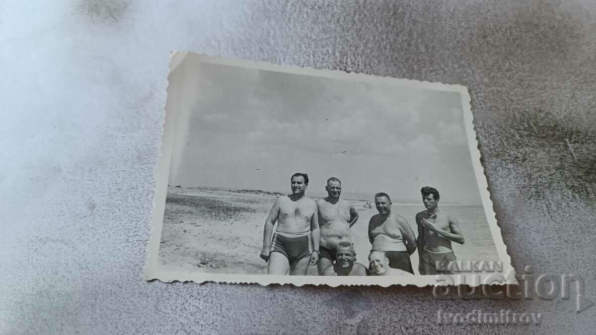 Photo Six men in swimsuits on the beach