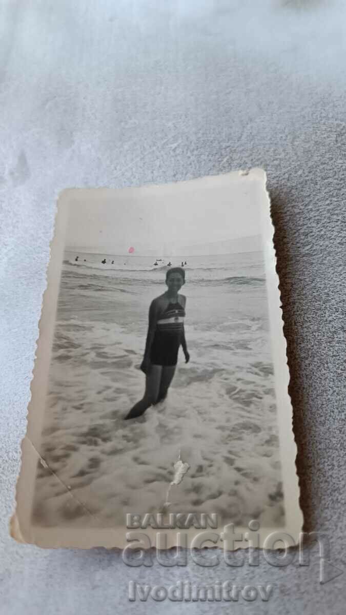 Foto Fată tânără într-un costum de baie pe plajă