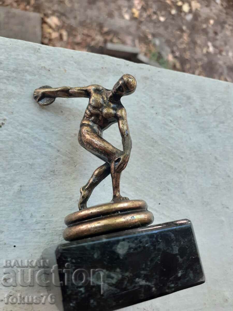 Auction A small metal figurine of a discus thrower Auction A small metal figurine of a discus thrower