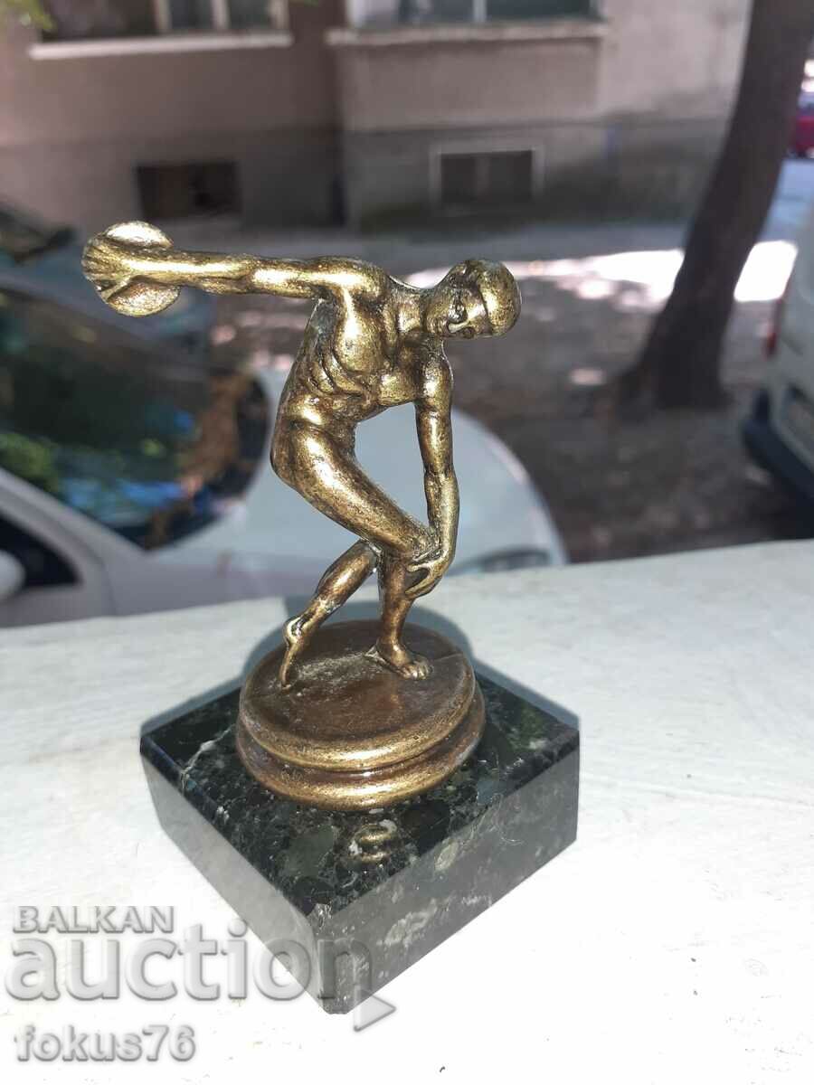 A small metal figurine of a discus thrower