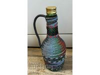 Old wicker bottle with braid, bottle glass jar