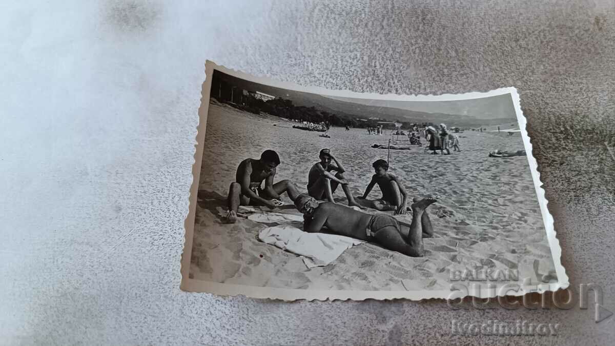 Photo Man and three boys on the beach