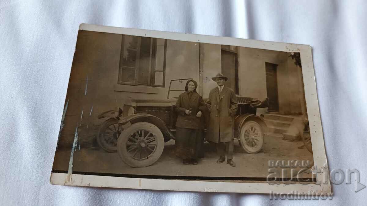 Photo A man and an elderly woman in front of a vintage car