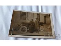 Photo A man and an elderly woman in front of a vintage car