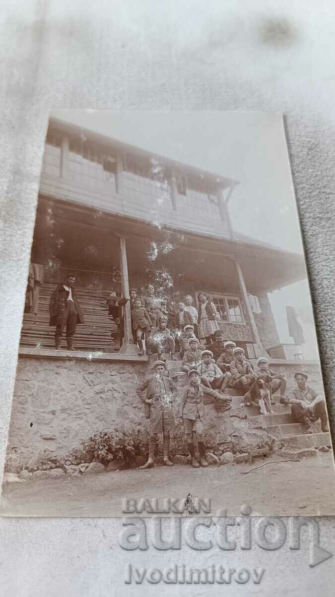 Foto Bărbați, băieți și fete, în fața unei cabane de munte