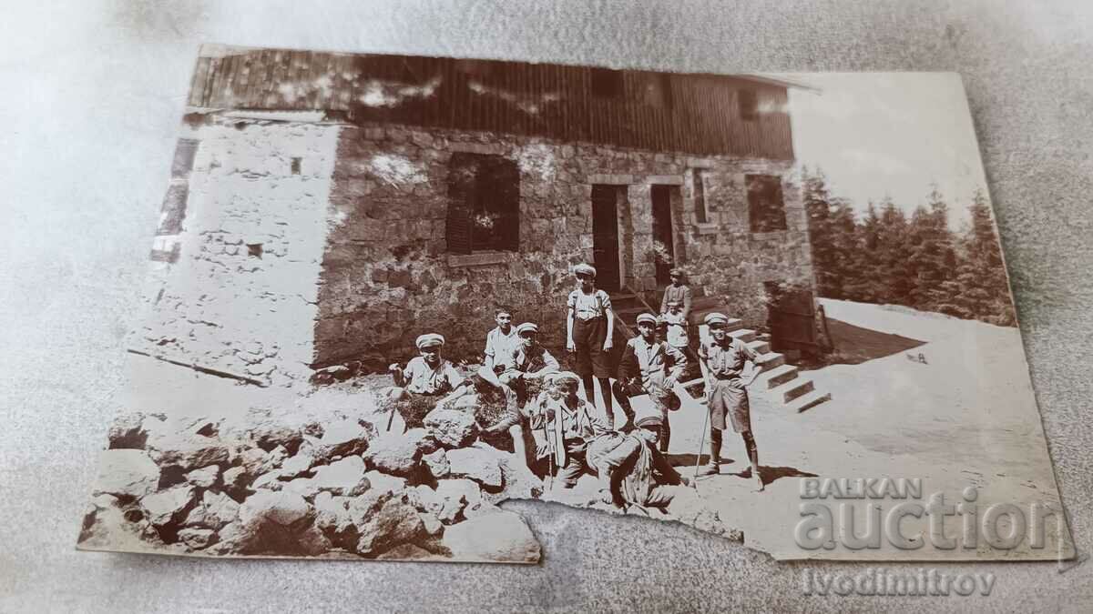 Foto Tineri în fața unei cabane de munte