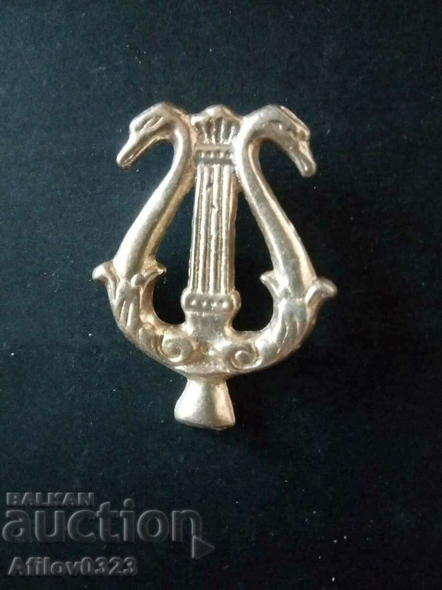 Lyre badge shaped with swan heads.