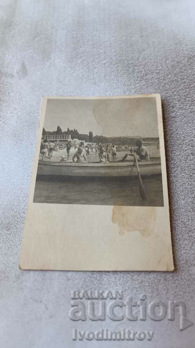 Photo Man and children in a boat on the seashore