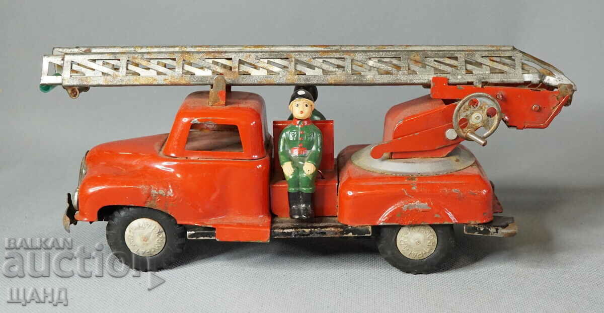 Old metal toy model fire truck with firefighters