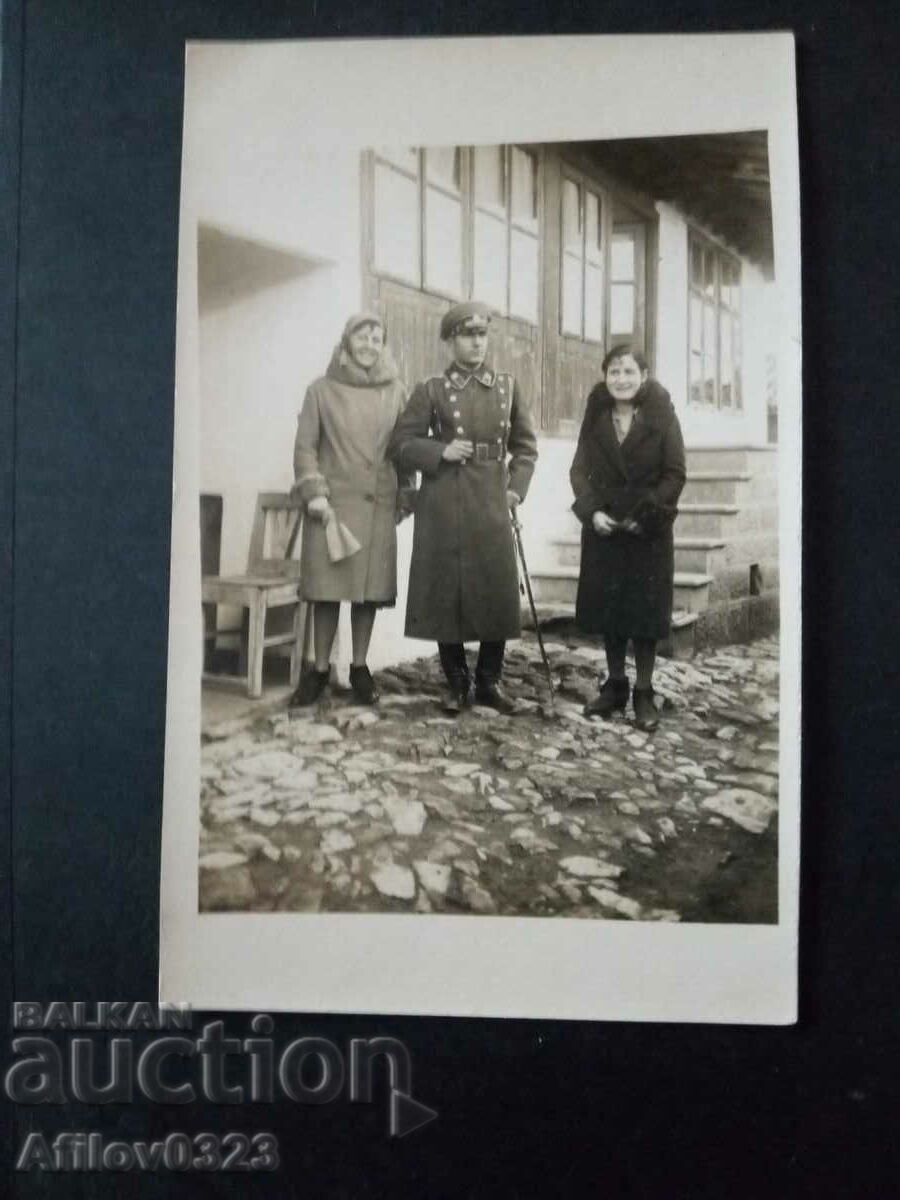 Old photo - officers tense in front of the ladies.