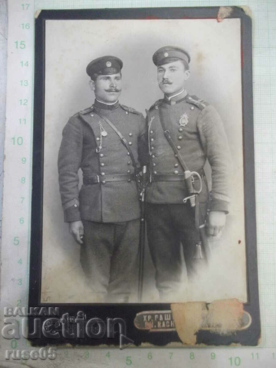 Old photo of two men in uniforms and cardboard sabers