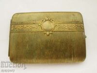 Old cigarette case with green stone on the button