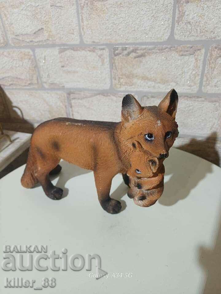 A figurine of a fox with a cub