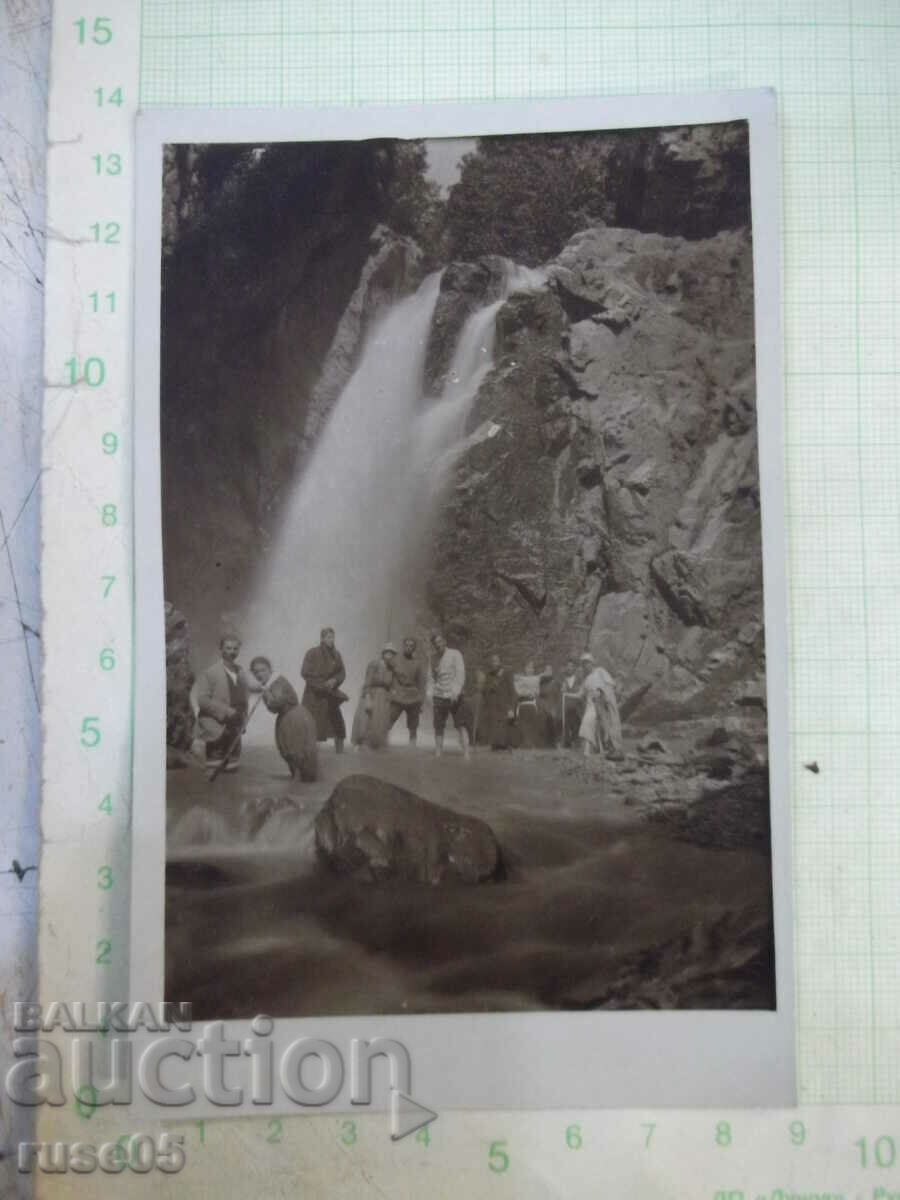 An old photo of a group of young people in front of the waterfall